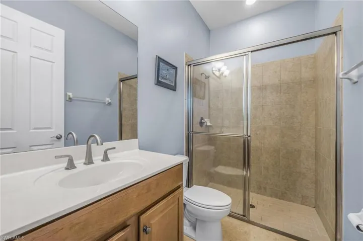 Bathroom with vanity, a stall shower, and tile patterned floors