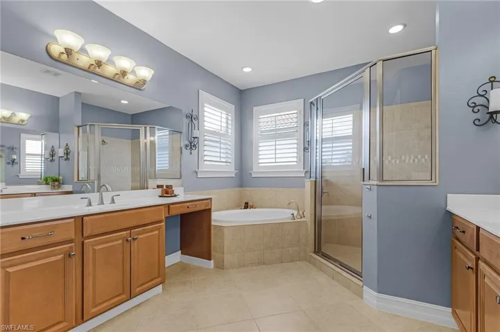 Full bathroom featuring vanity, a stall shower, a garden tub, tile patterned floors, and recessed lighting