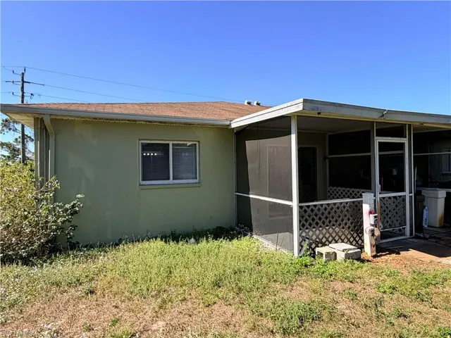 View of side of property featuring a sunroom and stucco siding