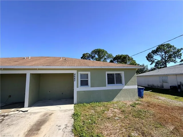 View of home's exterior with stucco siding and a lawn