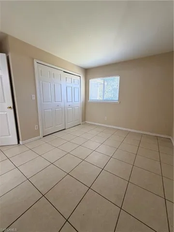 Unfurnished bedroom featuring light tile patterned floors and a closet