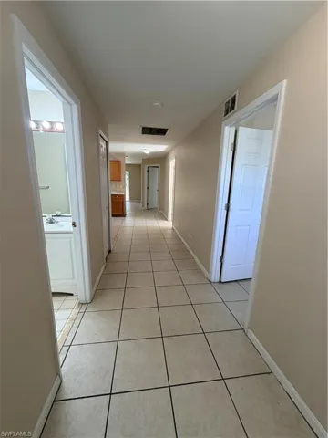 Corridor with light tile patterned floors and baseboards