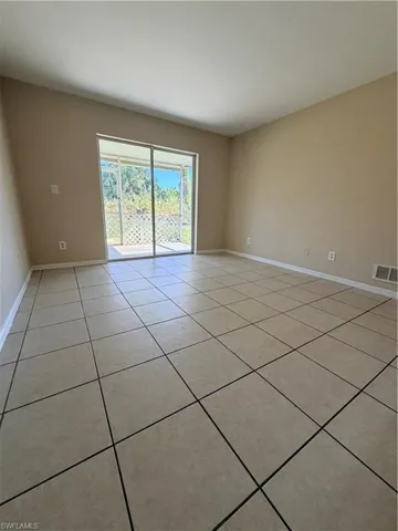 Unfurnished room featuring light tile patterned floors and baseboards