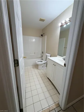 Full bath with vanity, shower / bath combination, and light tile patterned floors