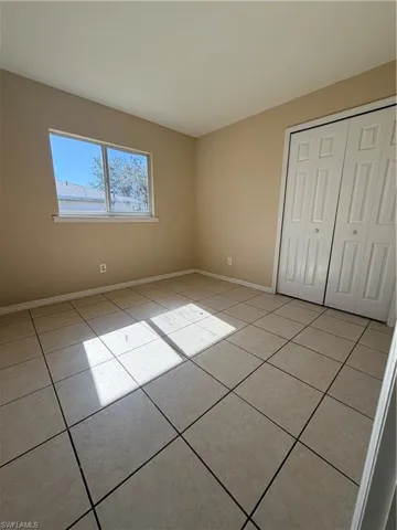 Unfurnished bedroom featuring a closet and light tile patterned flooring