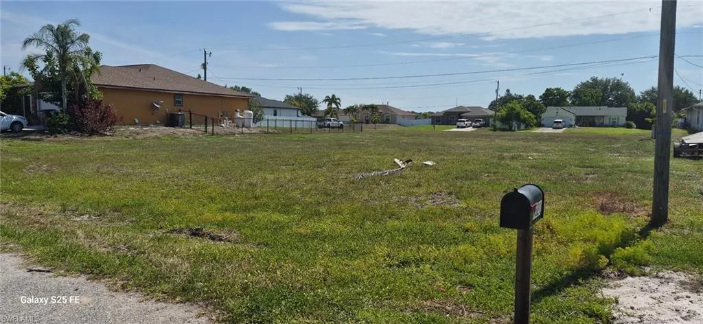 Expansive lot featuring a grass-covered surface and a curbside mailbox