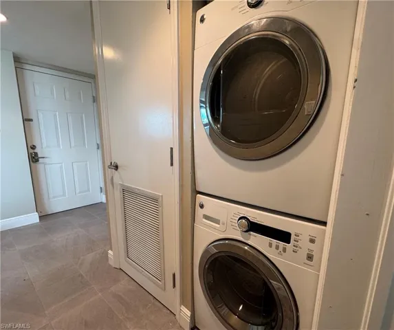 Laundry area featuring estacked washer and dryer and baseboards