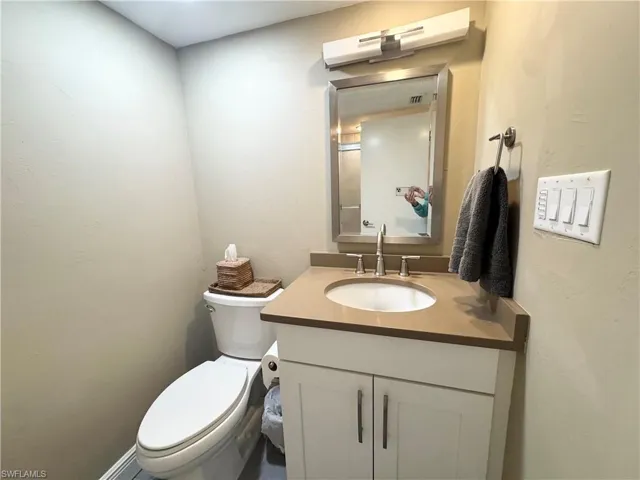 Half bath featuring vanity and a textured wall