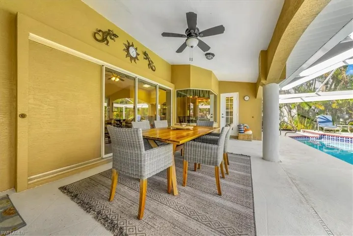 View of patio with a lanai, an outdoor pool, ceiling fan, and outdoor dining area