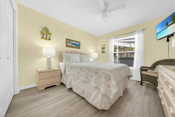 Bedroom with light wood-style flooring, ceiling fan, and a closet