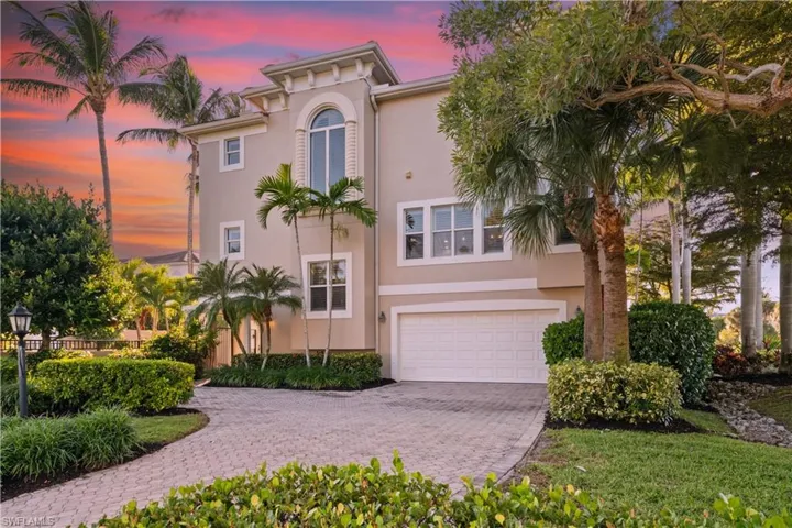 View of front of home featuring stucco siding, an attached garage, and decorative driveway