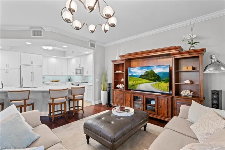 Living room featuring crown molding, dark wood-style flooring, a chandelier, and recessed lighting