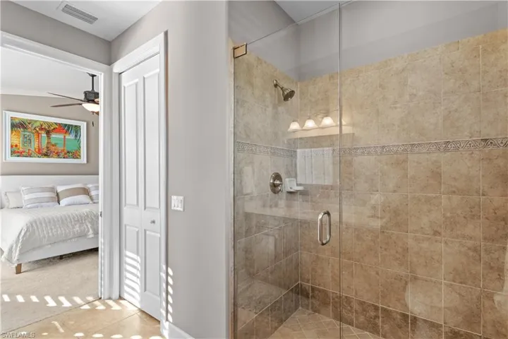 Bathroom featuring a stall shower, ensuite bath, ceiling fan, and a closet