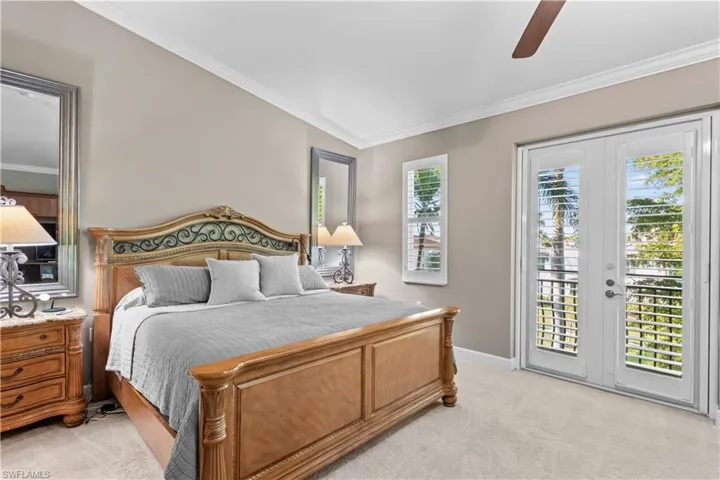 Bedroom featuring light colored carpet, access to outside, ceiling fan, ornamental molding, and french doors