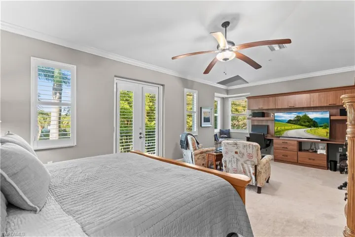 Bedroom with ornamental molding, light colored carpet, access to outside, french doors, and ceiling fan