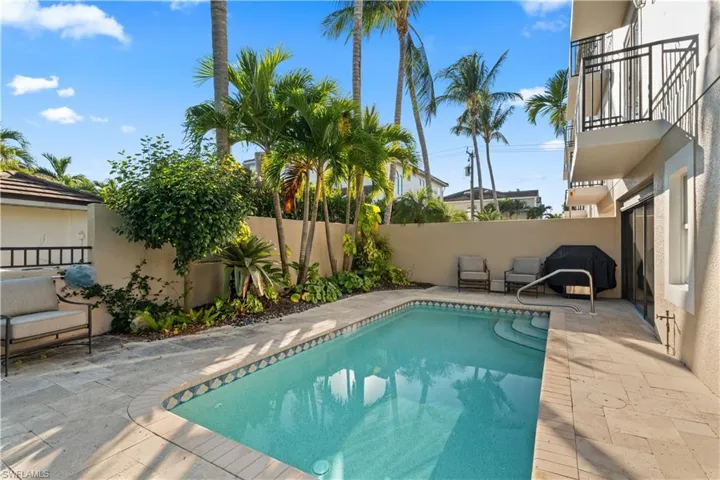 View of swimming pool featuring a patio area, a fenced backyard, and a balcony