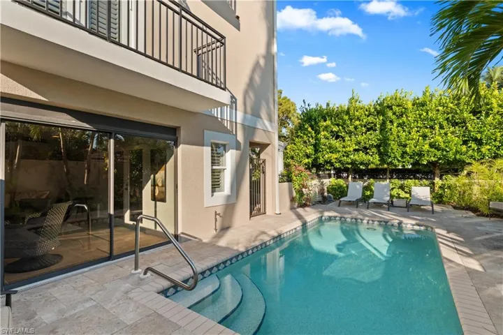View of pool with a balcony and a patio