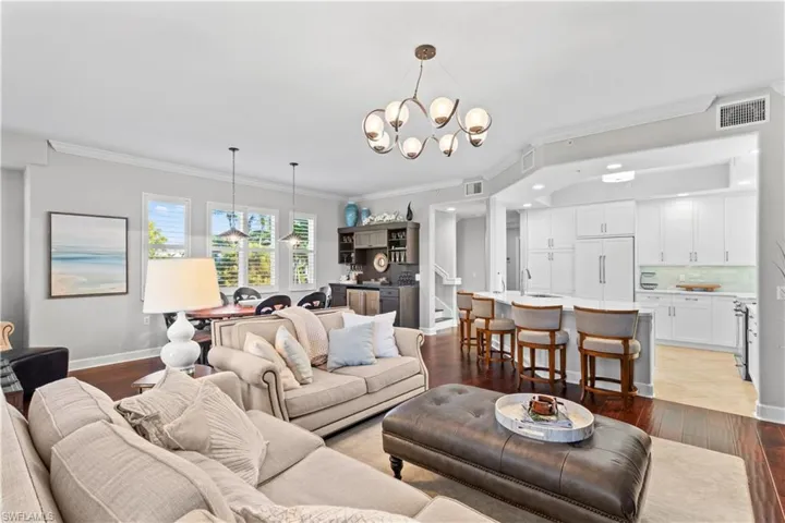 Living room featuring crown molding, hardwood / wood-style floors, and stairway