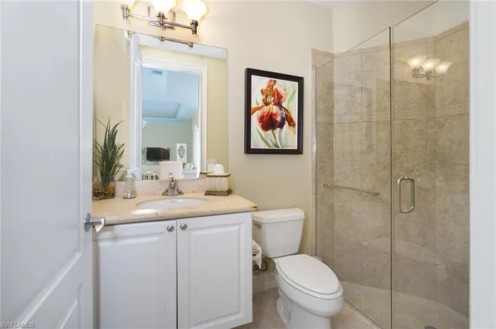 Full bath with a stall shower, vanity, and toilet