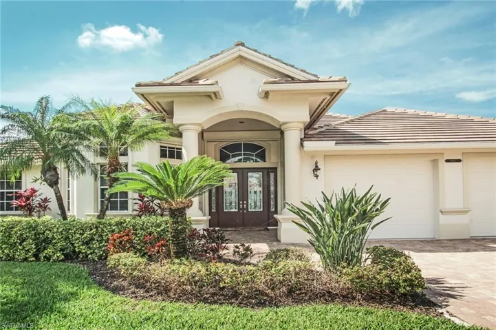 View of exterior entry featuring an attached garage, stucco siding, decorative driveway, and french doors