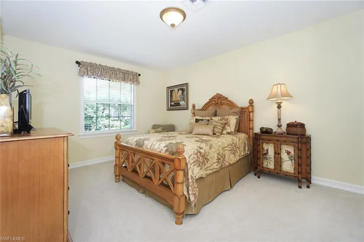 Bedroom featuring light carpet, baseboards, and visible vents