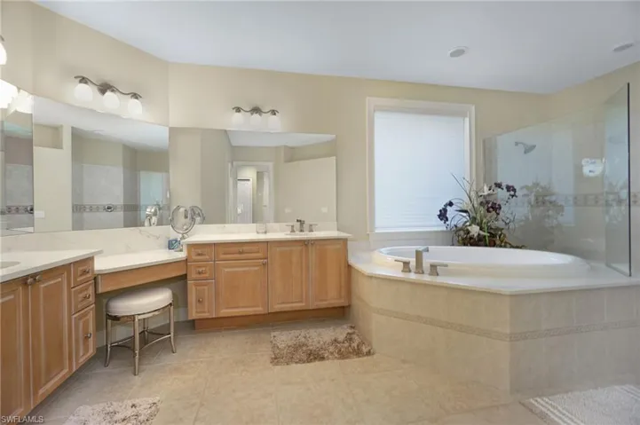 Full bathroom with walk in shower, tile patterned flooring, a garden tub, and vanity