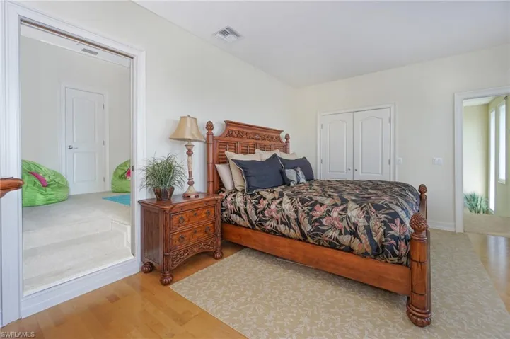 Bedroom featuring light wood-type flooring, a closet, and visible vents