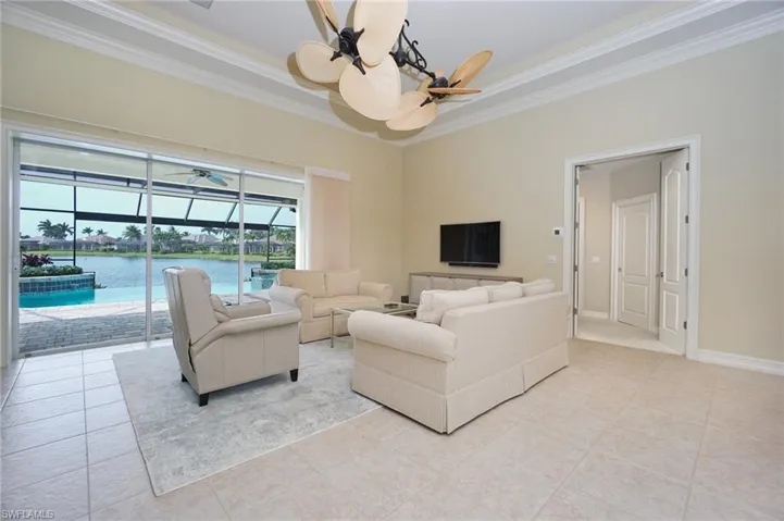 Living area with ornamental molding, a sunroom, and light tile patterned flooring