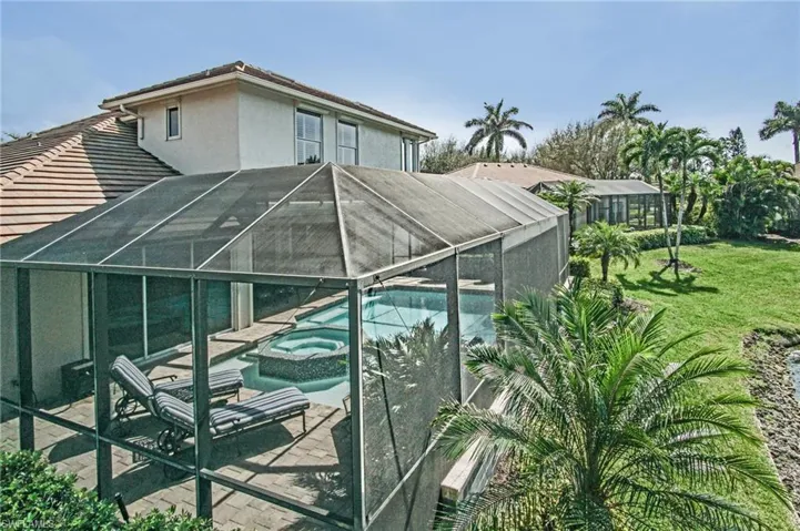 View of pool featuring a yard, a lanai, a patio area, and a pool with connected hot tub