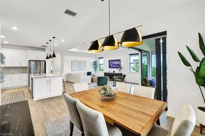 Dining space with light tile flooring and decorative light fixtures