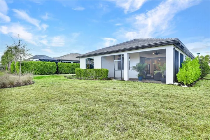 Rear view of property with a lawn and stucco finish
