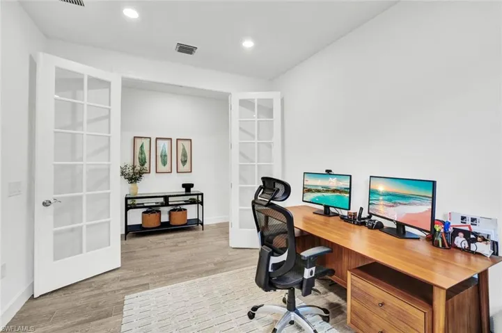 Den/Flex Room with french doors, light tile flooring and recessed lighting
