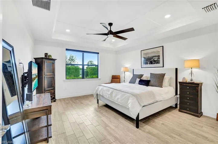Master Bedroom featuring light colored tiled floors, ceiling fan, recessed lighting, and a detailed tray ceiling