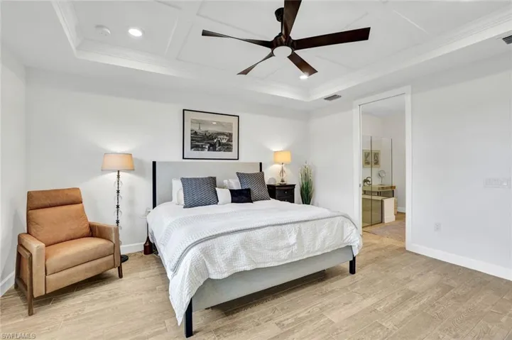 Master Bedroom with recessed lighting, detailed tray ceiling, light colored tile flooring, and a ceiling fan