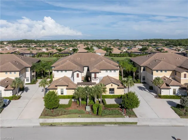 Mediterranean-style residential community with tiled roofs, stucco exteriors, and mature tropical landscaping