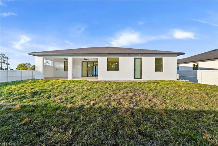 Rear view of property with ceiling fan, a patio area, and stucco siding