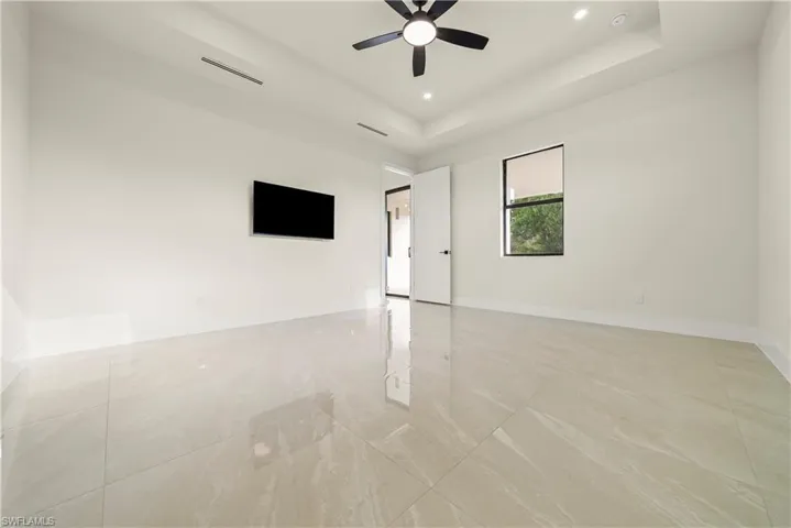 Spare room with recessed lighting, ceiling fan, and a raised ceiling