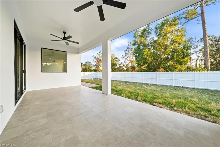 Fenced backyard with a ceiling fan and a patio
