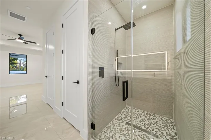 Bathroom with a shower stall, ceiling fan, and recessed lighting