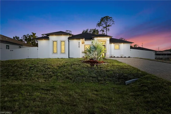 Prairie-style house with a gate and stucco siding