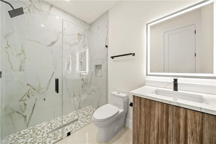 Full bath with vanity and a marble finish shower