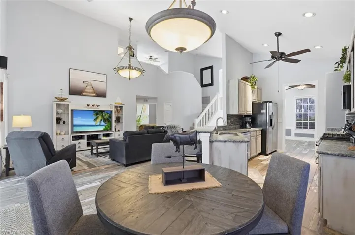 Dining space featuring a ceiling fan, light wood finished floors, vaulted ceiling, and recessed lighting