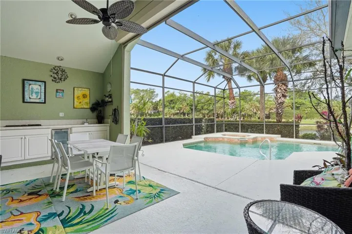 Integrated pool / hot tub with a sunroom, glass enclosure, a patio area, and outdoor dining area