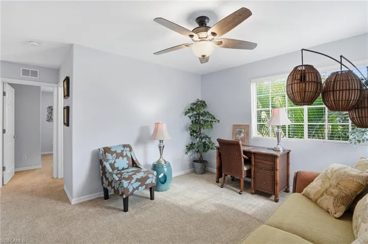 Office area featuring light carpet and a ceiling fan