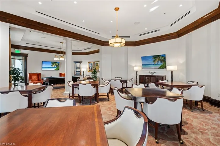 Dining area with decorative columns and a tray ceiling