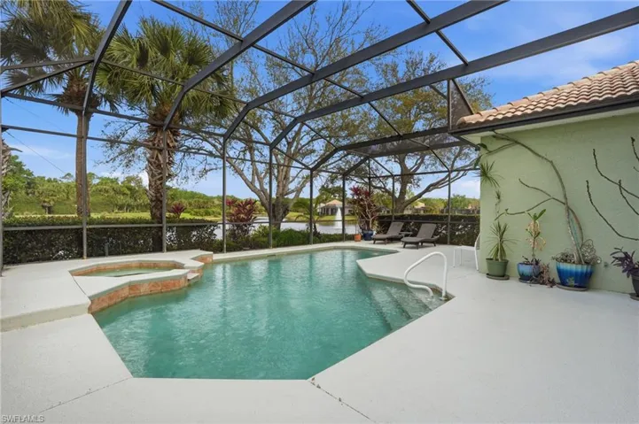Combined pool / hot tub featuring a patio area, glass enclosure, and a sunroom