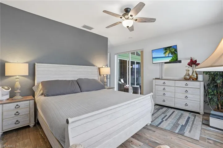 Bedroom with wood finished floors, a ceiling fan, and access to exterior