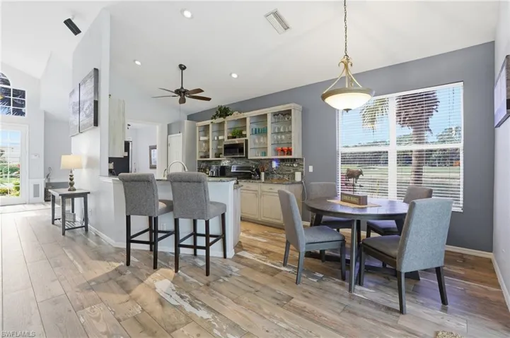 Dining area featuring light wood-style floors, vaulted ceiling, recessed lighting, and ceiling fan