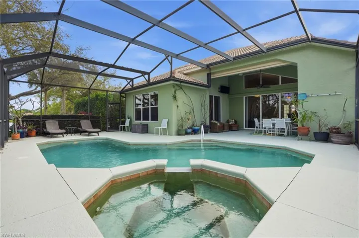 Relaxing pool / spa featuring a sunroom, outdoor dining space, a lanai, and a patio area