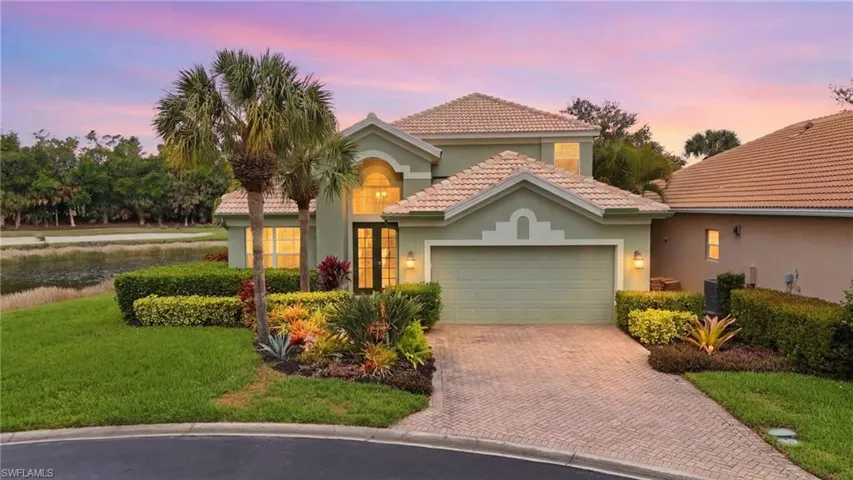 Mediterranean / spanish-style home featuring stucco siding, a garage, a front yard, and a tiled roof